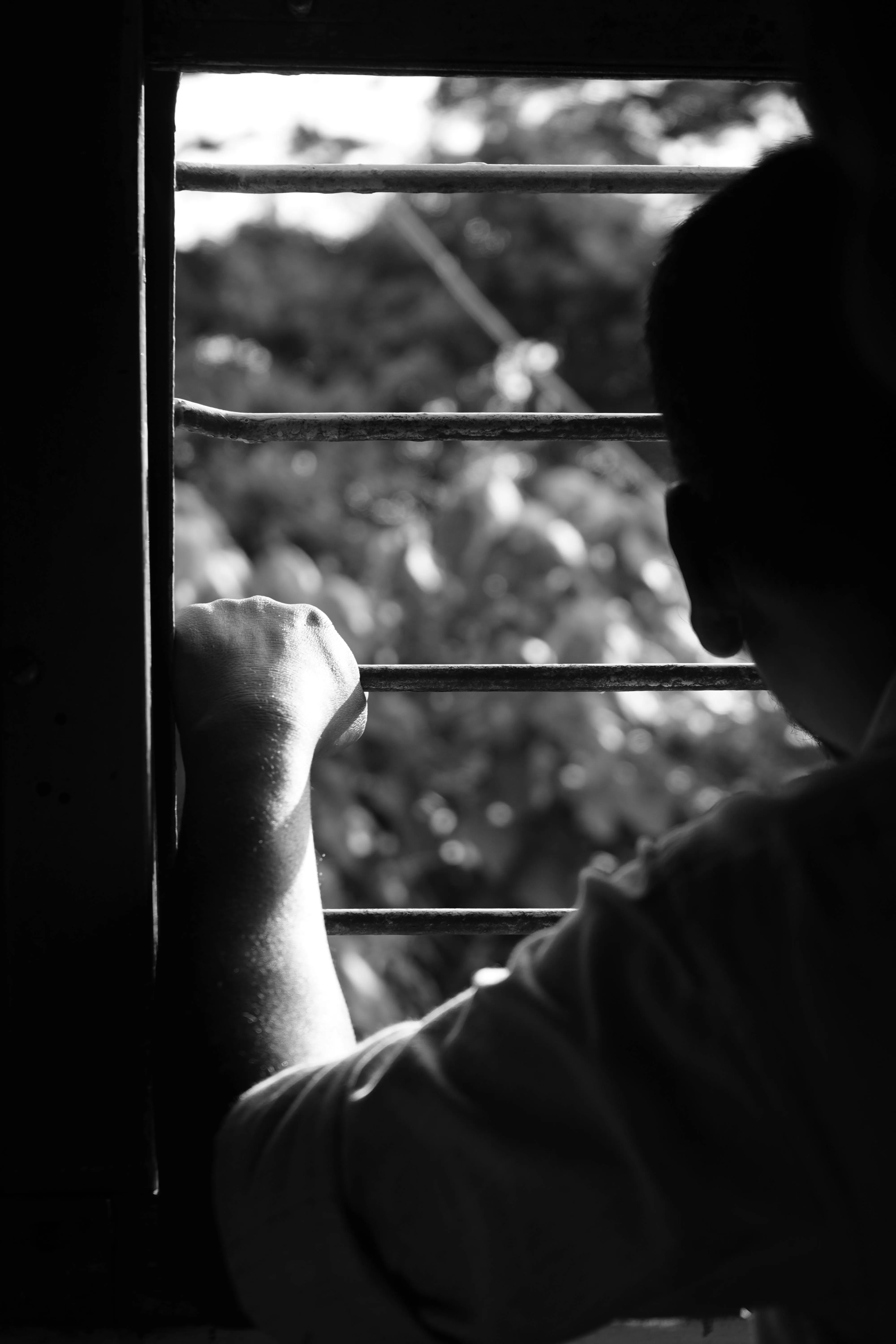 Silhouette gripping bars and looking out, representing the leadership prison we build for ourselves
